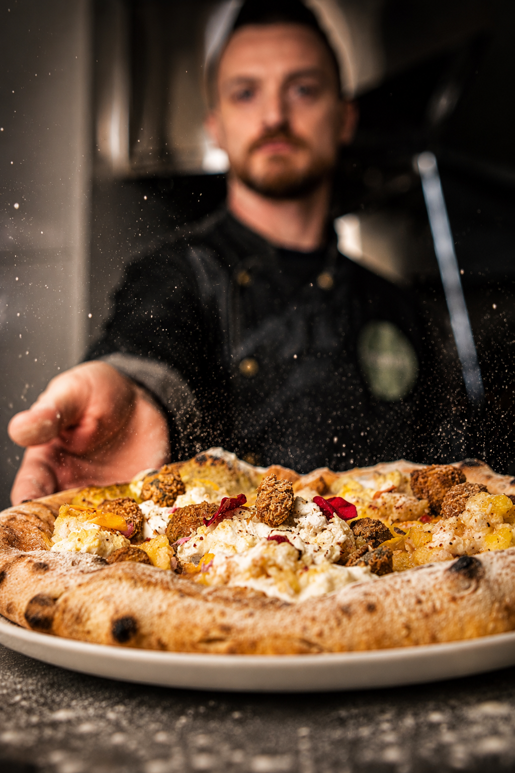 Un chef presenta una pizza recién preparada